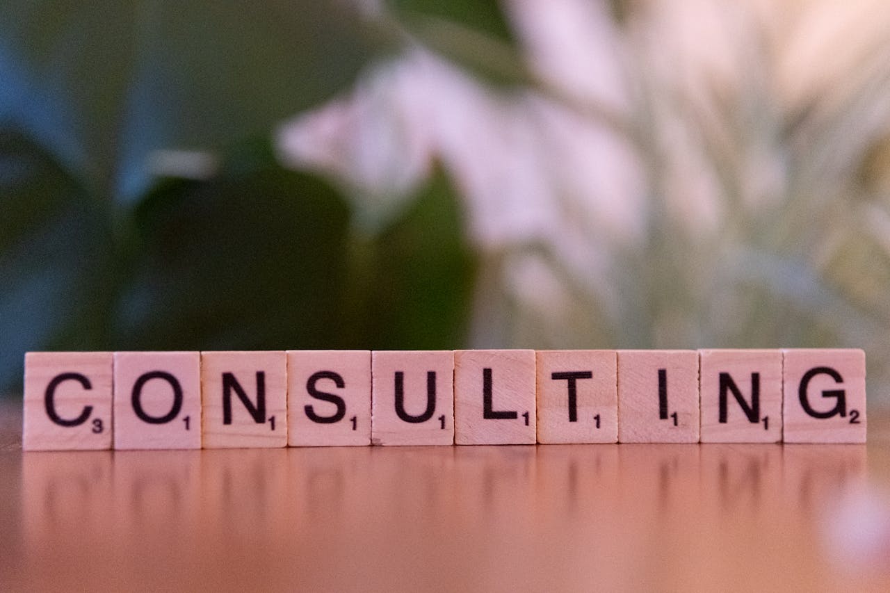 Wooden letter tiles spelling 'Consulting' with a blurred background. Ideal for business concepts.
