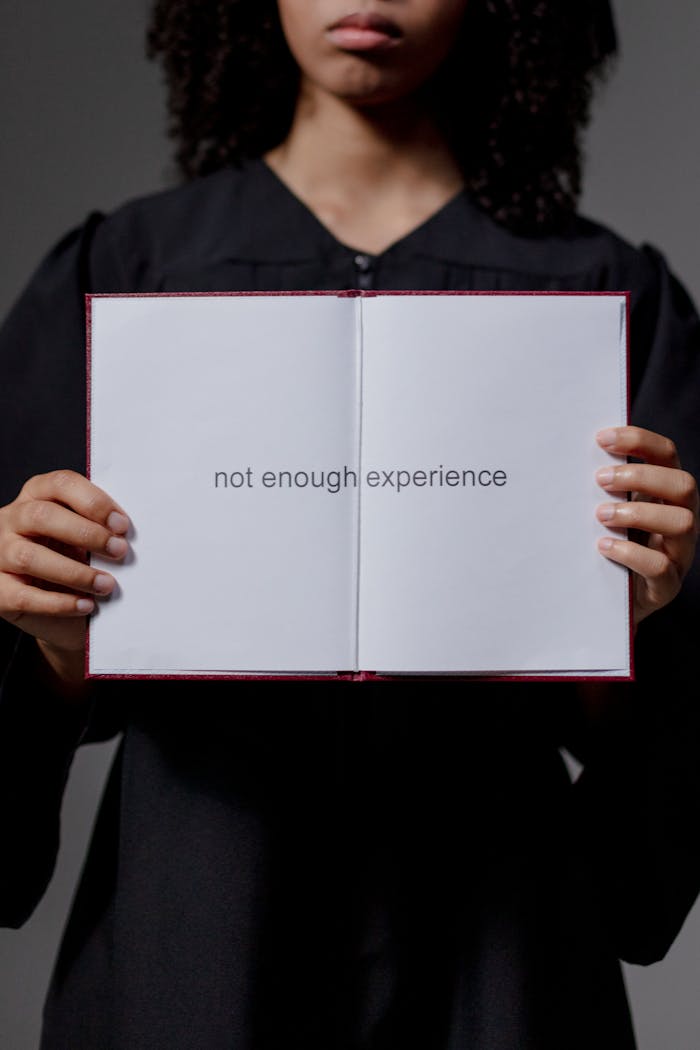 A graduate in a cap and gown holding a diploma with the text 'not enough experience'.